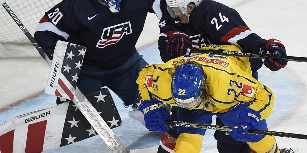 Axel Jonsson Fjällby tar stryk framför kassen i Juniorkronornas förlustmatch mot USA i genrepet inför junior-VM.