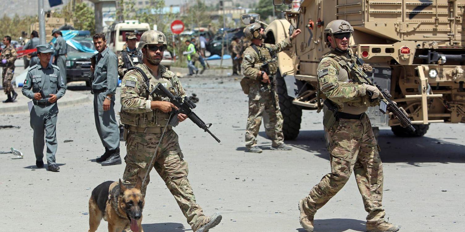 NATO and Afghan security forces walk at the site of a suicide attack in Kabul, Afghanistan, Sunday, Aug. 10, 2014. A suicide car bomber attacked the NATO convoy moving through Afghanistan's capital Sunday, killing at least several civilians and wounding more than 35 in an assault claimed by the Taliban, authorities said. (AP Photo/Rahmat Gul) / TT / kod 436