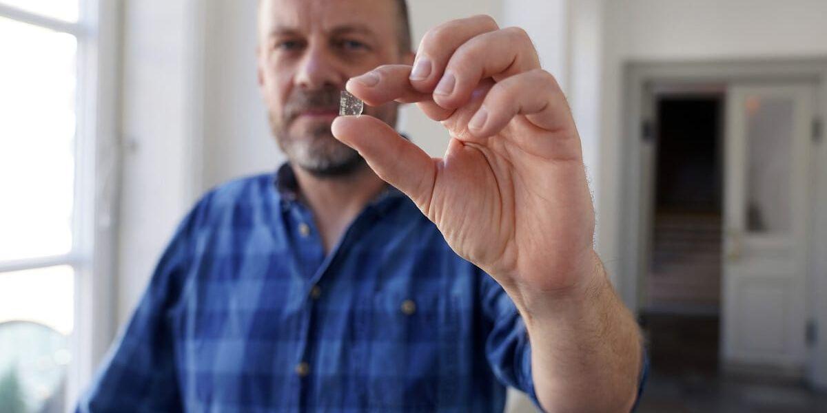 Mads Dengsø Jessen, forskare vid Danmarks Nationalmuseum, visar upp en bit fönsterglas från vikingatiden.