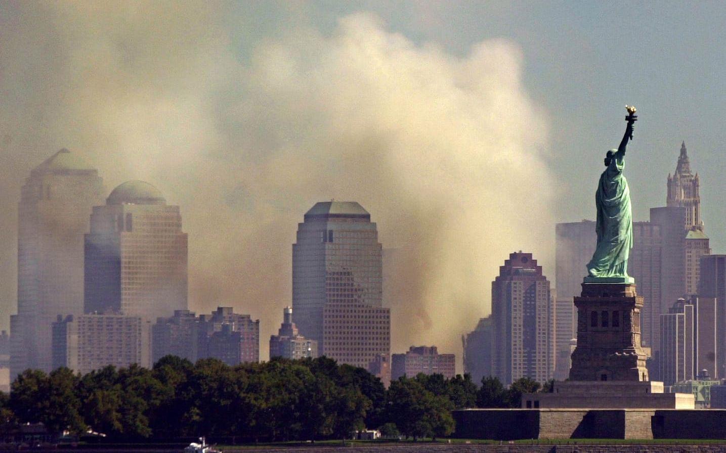 With the Statue of Liberty standing in New York Harbor, smoke rises from lower Manhattan following the destruction of buildings at the World Trade Center in New York, Wednesday Sept. 12, 2001.  Two hijacked commercial aircraft crashed into the center's towers. (AP Photo/Charles Krupa)